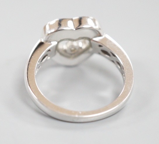 A modern 750 white metal and 'floating diamond' heart shape dress ring, size M, gross weight 6.4 grams.